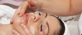 Woman relaxing as she receives her illuminate signature exfoliating facial.